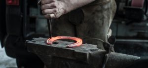Blacksmith making metal horse shoe