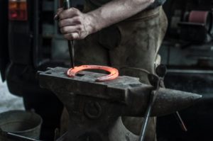 Blacksmith making a metal horse shoe