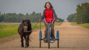 Supertonk the mini horse wearing Blue CLB's with Patty on a bicycle!