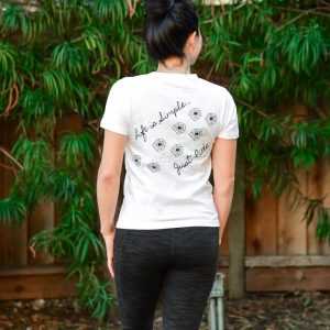 Back view of a woman in a Life is Simple, Just Ride t-shirt, perfect for equine enthusiasts and Cavallo gear fans.