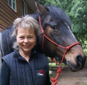 Smiling woman with horse, promoting Cavallo hoof boots and equine gear, showcasing quality horse care products.