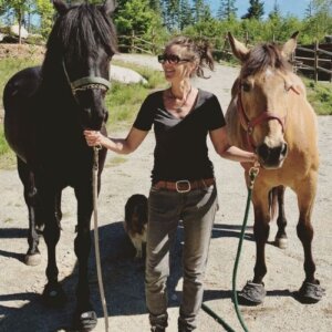 Woman with two horses in Cavallo hoof boots, showcasing premium equine gear for optimal horse care and comfort outdoors.