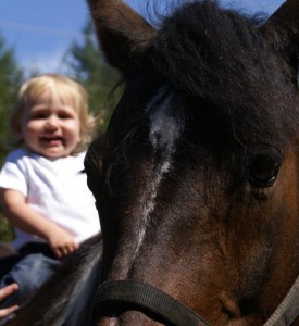 Child riding a horse with Cavallo hoof boots, showcasing premium equine gear and essential horse care products.