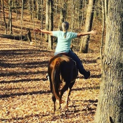 Rider enjoying trail ride on horse wearing Cavallo hoof boots in autumn forest; optimal equine gear for hoof protection.